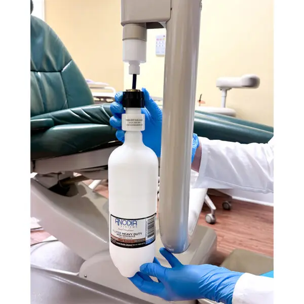 Gloved hands changing dental suction system bottle.